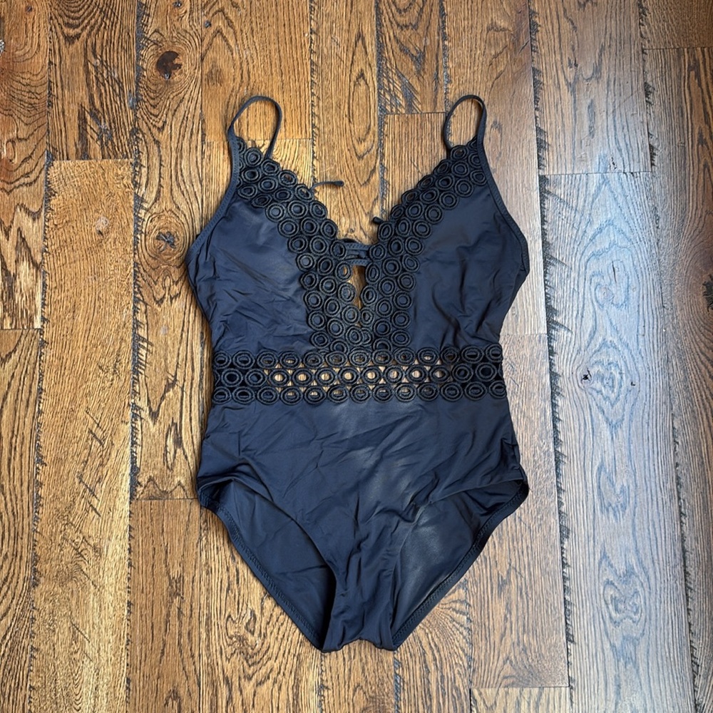 Becca black one-piece bathing suit with plunging bodice and elegant detailing.